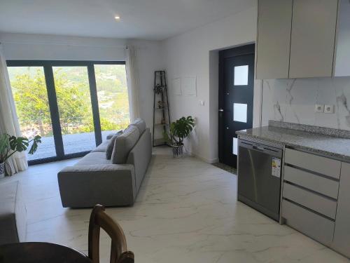 ein Wohnzimmer mit Couch und Küche in der Unterkunft Casa Sambinho II Bela Vista in Rio Caldo