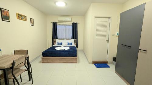 a bedroom with a bed and a dining room table at Shady Palms Guest House Cha Am Beach in Cha Am