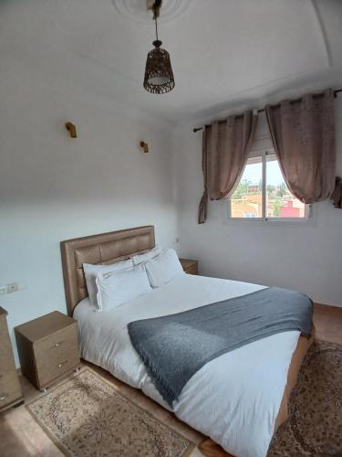 a bedroom with a large bed and a window at Appart'hotel Dior Lamane in Azilal