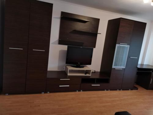 a living room with a tv and wooden cabinets at House Teo in Văleni