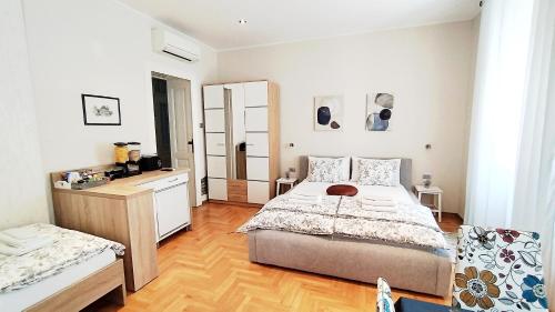 a bedroom with a large bed and a wooden floor at Lavender - City Room with free parking in Pula