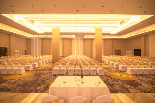 an empty banquet hall with white chairs and tables at Aurum by R J Resorts in Siliguri