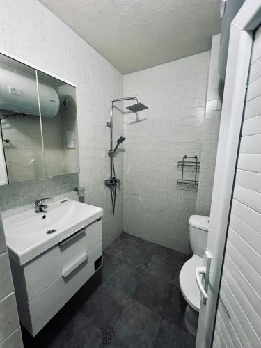 a white bathroom with a sink and a toilet at Limani Guest house in Sozopol