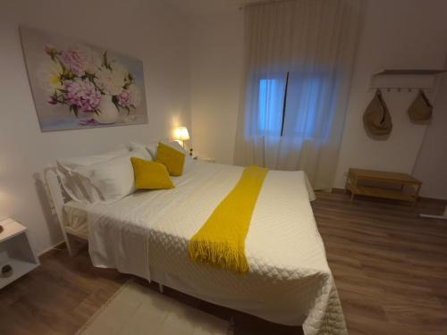 sypialnia z dużym łóżkiem z żółtymi poduszkami w obiekcie Cloud9Rest & Fly w mieście Koropi