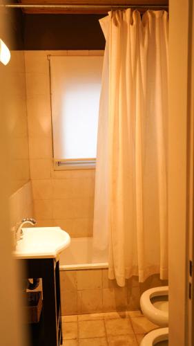 a bathroom with a white shower curtain and a sink at Las termas de los Molles in Los Molles