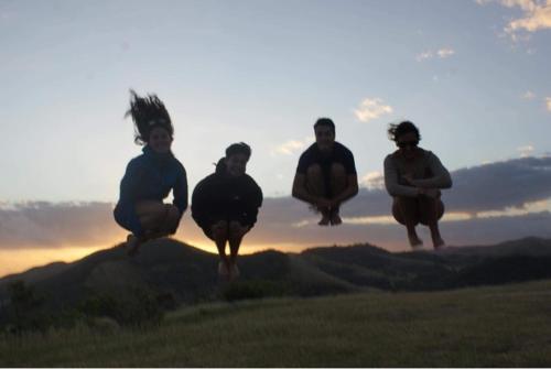 a group of people jumping on top of a hill at Poétitude in Bourail