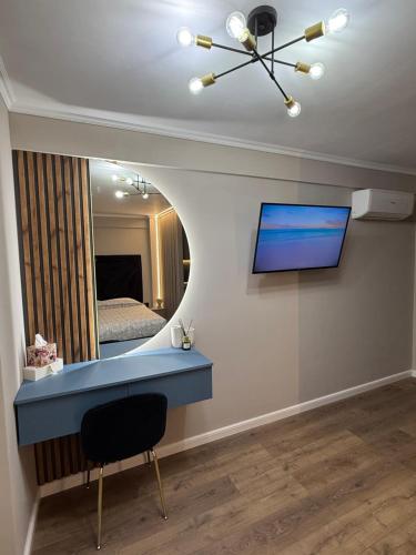 Habitación con escritorio azul y espejo. en Noble Stay, en Saturn
