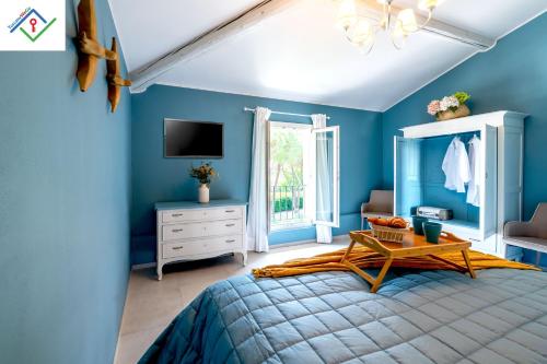 a blue bedroom with a bed and a tv at La Mansarda Chic by TuscanyWeGo in Prato