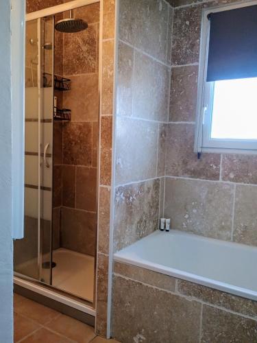 une salle de bain avec une douche avec une porte vitrée dans l'établissement Villa Beau Soleil Piscine Jardin Parking, à LʼIsle-sur-la-Sorgue