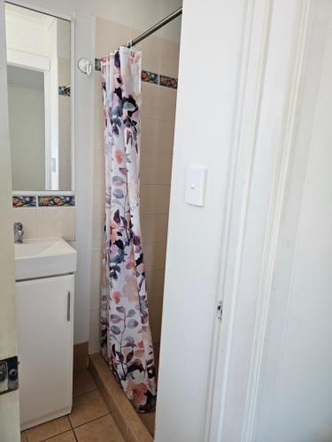 a shower curtain in a bathroom with a sink at Absolute Oceanfront Tourist Park in Bargara