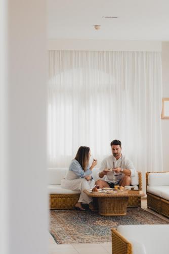 een man en vrouw zittend op een bank in een woonkamer bij Hotel Degli Aranci in Vieste