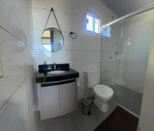 a bathroom with a toilet and a sink and a mirror at Lofts Clariô in Alto Paraíso de Goiás