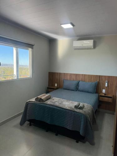 a bedroom with a bed and a window at Lofts Clariô in Alto Paraíso de Goiás