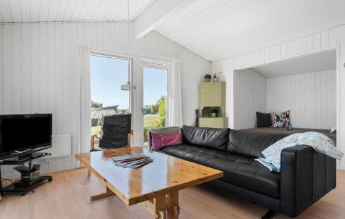 a living room with a black couch and a table at Stunning Home In Haderslev With Sauna in Haderslev