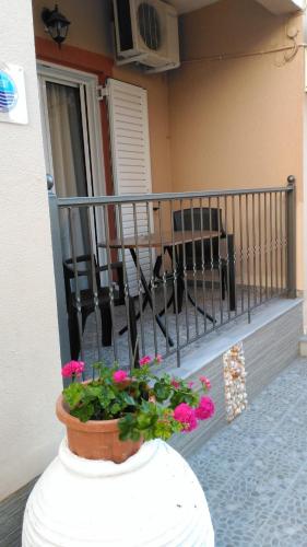 a porch with a pot of flowers on a balcony at Paraskevi's Luxury Studios in Parga