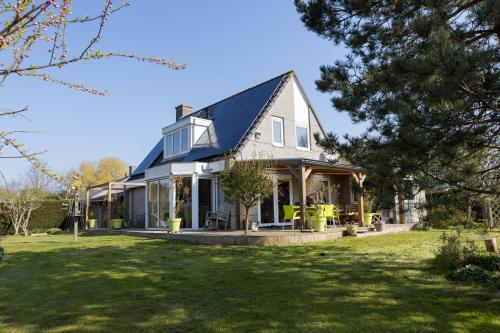 a house with a blue roof and a yard at Vegan B&B De Groene Mus in Wervershoof