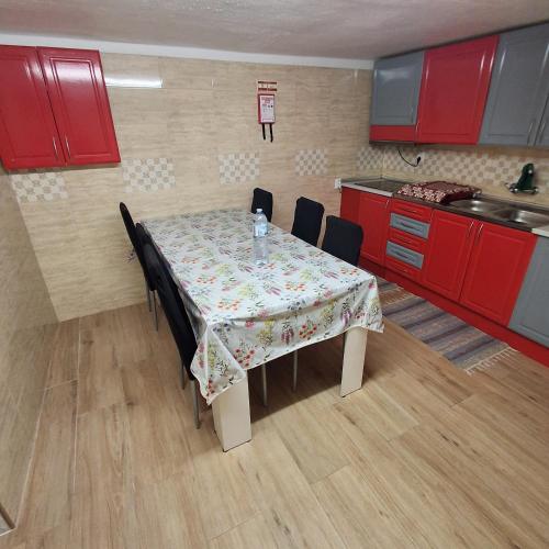 a kitchen with a table with chairs and red cabinets at Cantinho da Familia in Avis