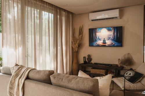 a living room with a couch and a tv at Ka'ana Condo in Tulum