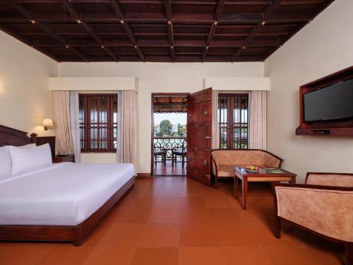 a bedroom with a bed and a flat screen tv at Sterling Lake Palace Alleppey in Alleppey