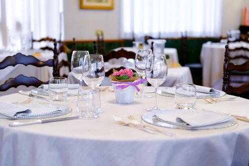 a table with wine glasses and a bowl of flowers on it at Hotel Monte Rosa in Chiavari