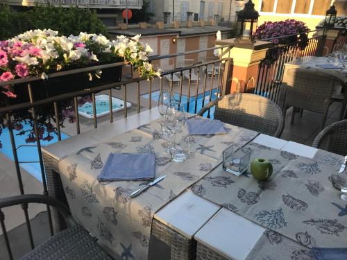 a table with glasses and an apple on a balcony at Hotel Monte Rosa in Chiavari