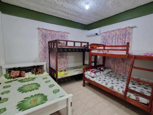 a room with two bunk beds and a table at Sales-Marzan Pension House Rental in Aringay