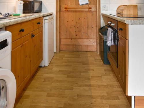 a kitchen with wooden cabinets and a wooden floor at Uk46717 - The Orchard in Plumstead