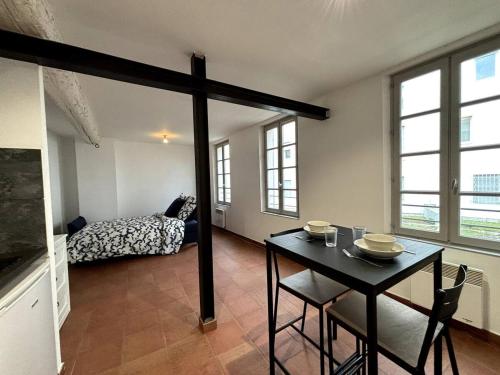 une pièce avec une table, des chaises et un lit dans l'établissement Studio au calme sur Avignon, à Avignon