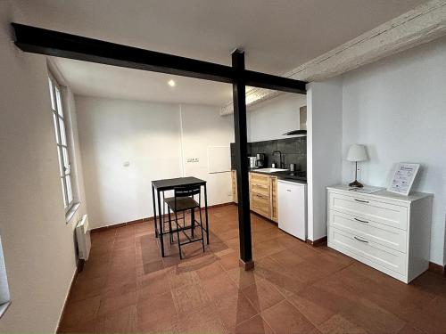 - une cuisine avec une table au milieu d'une pièce dans l'établissement Studio au calme sur Avignon, à Avignon
