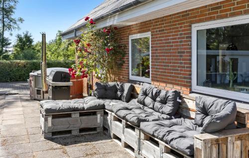 a couch sitting on the side of a brick building at 4 Bedroom Amazing Home In Ørsted in Ørsted