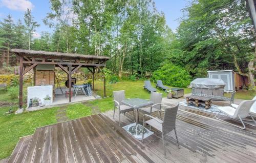 a backyard with a wooden deck with a grill at Lovely Home In Sösdala With Sauna in Sösdala