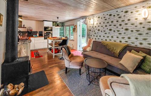 a living room with a couch and a stove at Lovely Home In Sösdala With Sauna in Sösdala
