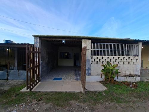 a building with an open door and a gate at Casa 2 minutos a pé da Praia de INDAIÁ in Bertioga