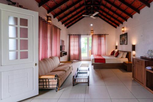 a living room with a couch and a bed at After the Rains - Rainforest Lodge in Meppādi