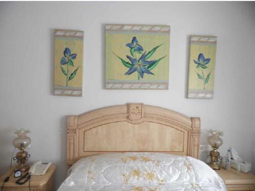 a bedroom with a bed and three paintings on the wall at Torrox costa apartamento in Torrox Costa