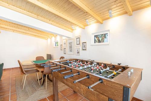 a room with a foosball table and chairs at Alma Alentejo Villa in Bicos