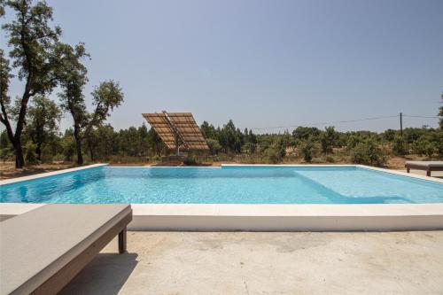 a large swimming pool in the middle of a yard at Alma Alentejo Villa in Bicos