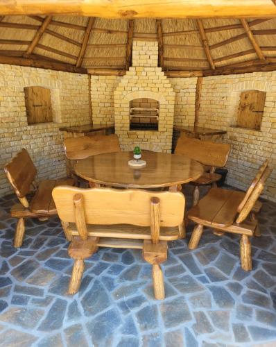 a table and chairs in a room with a brick oven at Osada Kuboski Dom z Bali Leśny Zakątek in Kamesznica
