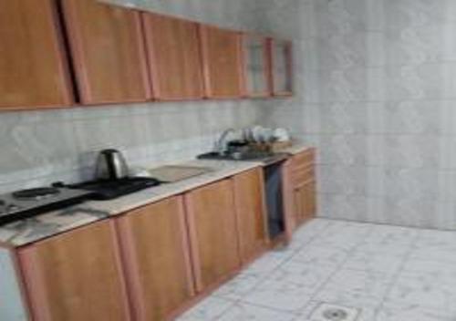 a small kitchen with a sink and a stove at مركز السراج للوحدات المخدومة in Jeddah