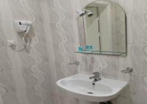 a white bathroom with a sink and a mirror at مركز السراج للوحدات المخدومة in Jeddah