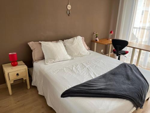 - une chambre avec un lit blanc et une couverture noire dans l'établissement Très beau 3 pièces spacieux lumineux et climatisé, à Nice