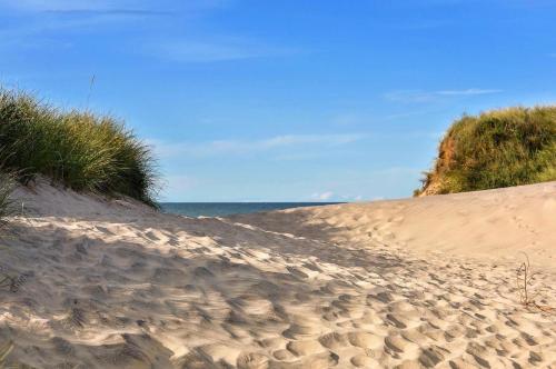 a sandy beach with grass and the ocean at Am Sahlenburger Strand 04 in Cuxhaven