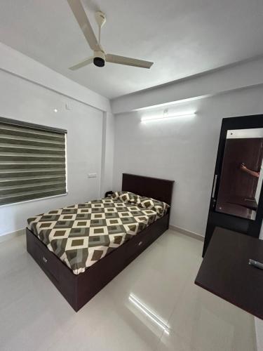 a bedroom with a bed and a ceiling fan at Samriddhi Homestay in Trivandrum