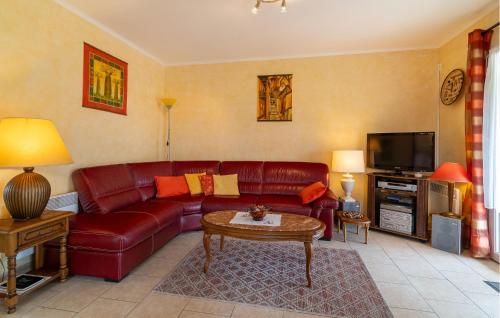 sala de estar con sofá de cuero rojo y TV en Beautiful Home In Lauris With Wifi, en Lauris