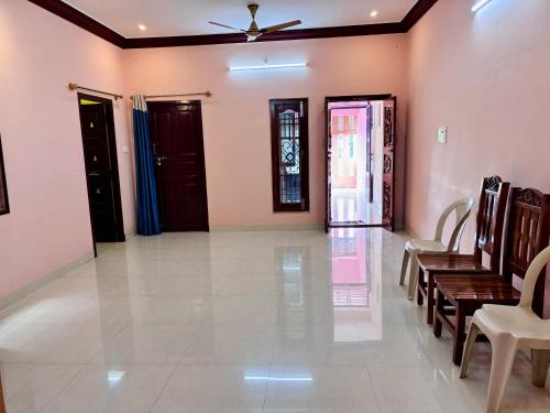 a living room with a ceiling fan and chairs at Sree Paradise Homestay in Tiruvannāmalai