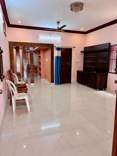 a living room with a piano and a chair at Sree Paradise Homestay in Tiruvannāmalai