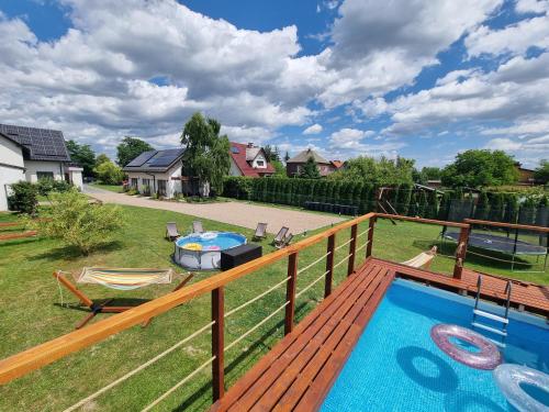 a deck with a swimming pool on top of a yard at Lawendowy Domek Boutique Resort, Zator, Przeciszów in Zator