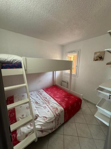 une chambre avec un lit superposé avec une échelle dans l'établissement coquet appartement 1 chambre avec parking bord de plage, à Sète