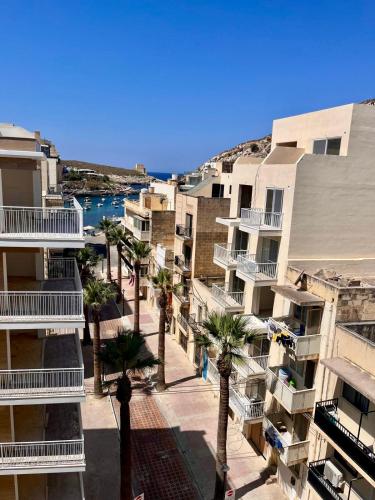 an aerial view of a city with palm trees and buildings at Seaside apartment in the heart of Xlendi Gozo in Xlendi