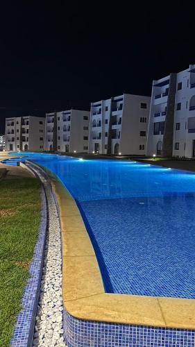 a swimming pool in front of a building at night at Luxury apartment near golf beach in Cabo Negro